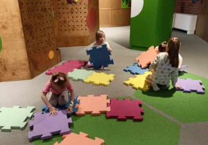 Dziewczynki układają puzzle z żywiołami.