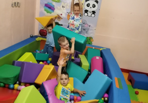 Chłopcy bawią się w basenie z kulkami.