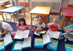 Basia, Sebastian i Mateusz ogladają książki.