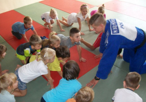 Trener pokazuje prawidłową pozycję w judo.