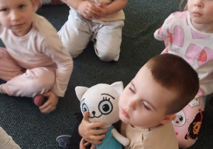 Wojtuś przytula maskotkę Kici Koci.