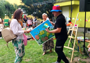 Mama Marysi przekazuje pieniądze za wylicytowany obraz.