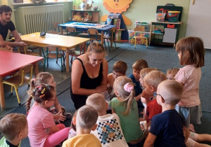Pani Monika opowiada dzieciom, co przyniosła do przedszkola i co każde dziecko może sobie wykonać na ręce - tatuaż.