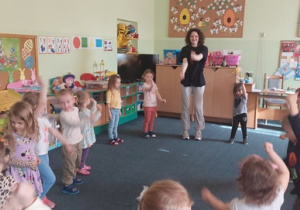 Dzieci uczą się tańca naśladując panią od rytmiki.