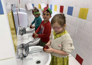Maja, Leon i Laura myją jabłka.