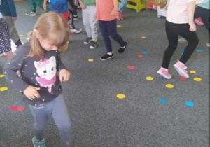 Dzieci z grupy "Pszczółki" spacerują wśród kolorowych kropek.