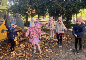 Dzieci zbierają jesienne liście.