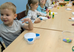 dzieci przyklejają elementy misia
