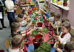 Dzieci tworzą swoje stroiki świąteczne.