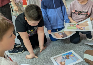 dzieci ogłądają karty z opowiadania
