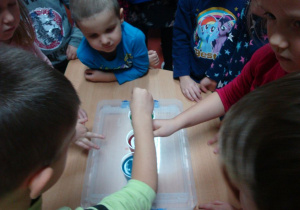dzieci mieszają różne ciecze w kubkach