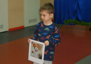 Chłopiec pokazuje obrazek z Misiem Uszatkiem.