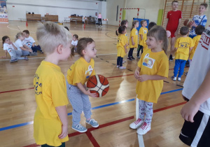 dzieci rzucają do siebie piłkę do koszykówki