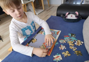 Oskar układa puzzle.