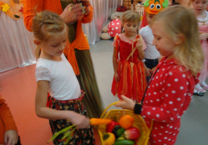 dziewczynka wyciąga warzywo z koszyka