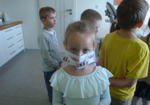 dziewczynka przymierza maskę ochronną