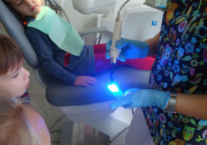 pani pokazuje laser dentystyczny