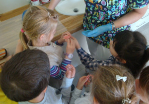dzieci oglądają protezę zębową