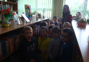 przedszkolaki razem z panią Olą stoją między regałami z książkami
