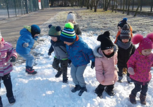 Dzieci tupią na śniegu.
