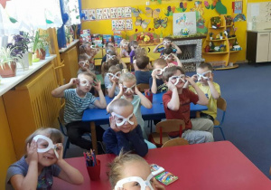 dzieci pokazują papierowe okulary