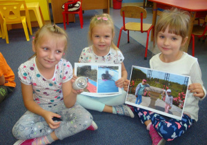 dziewczynki pokazują zdjęcia z wakacji