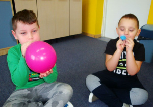 chłopcy nadmuchają swoje balony