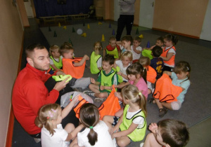 Dzieci z trenerami wkładają kamizelki.