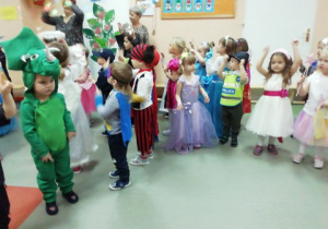 Dzieci tańczą w kółku.