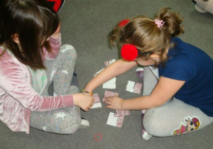 dziewczynki z grupy Biedronki układają kocie puzzle