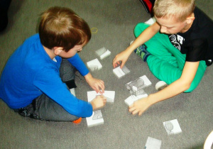 chłopcy z grupy Stokrotki układają kocie puzzle