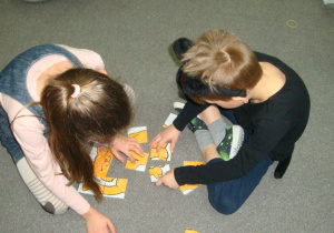 dzieci z grupy Pszczółki układają kocie puzzle