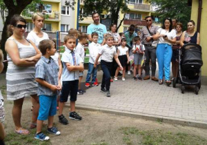 Dzieci i rodzice na placu przedszkolnym.