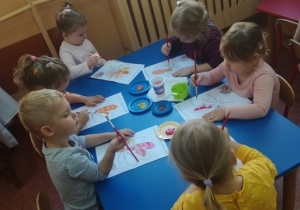Dzieci malują farbami liść kasztanowca.