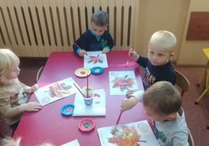 Chłopcy malują farbami liść kasztanowca.