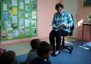 Dzieci z grupy słuchają wierszy czytanych przez panią.
