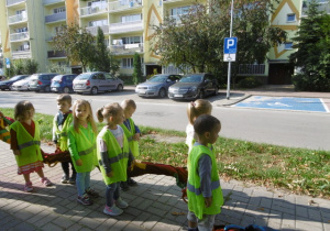 Na spacerze dzieci poznają znaki drogowe.