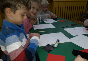 Dzieci przygotowują kawałki papieru do wyklejenia.