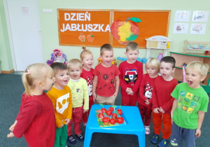 Dzieci prezentują swoją pracę - czerwone jabłuszka.
