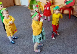 Dzieci inscenizują piosenkę o jabłuszku.