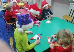 Dzieci przyklejaja portret Mikołaja.