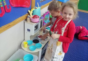 Dzieci bawią się w kąciku kuchennym.