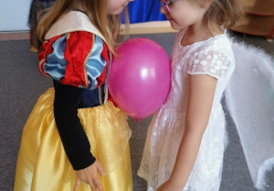 Księżniczka i Aniołek tańczą z balonem.