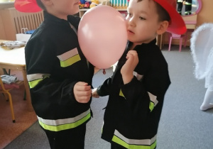 Strażacy tańczą z balonem.