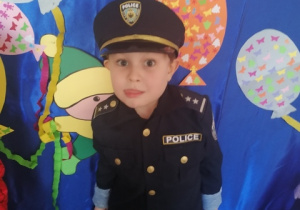 Chłopiec prezentuje strój policjanta.