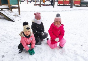 Dziewczynki lepią kule ze śniegu.