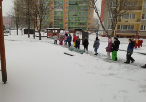 Dzieci podziwiają uroki białej zimy.