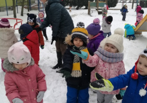Dzieci łapią gwizdki śniegowe.