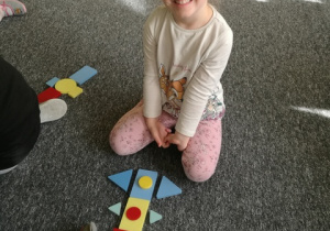 Nela i jej rakieta z figur geometrycznych.
