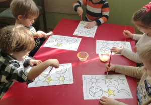 Dzieci malują obiekty w kosmosie.